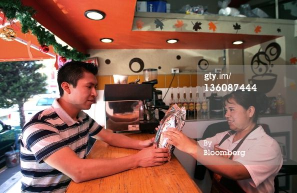 Juan Carlos Lopez, an adviser to the Cafe Guerrero Maya cooperative, left, leaves a bag of coffee 
to be sold at a store in Mexico City, Mexico on Monday, Dec. 19, 2011. Lopez is on a mission to 
cut out middlemen coyotes by linking the cooperative to the